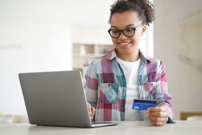 teen girl on computer with card
